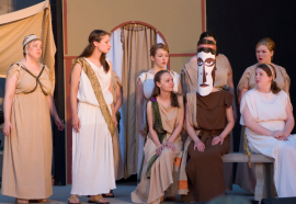 Andrea Braddy (masked) and ensemble members in Electra