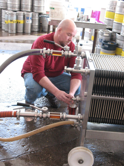 Brewer Scott Lehnert draws a mug from the filter