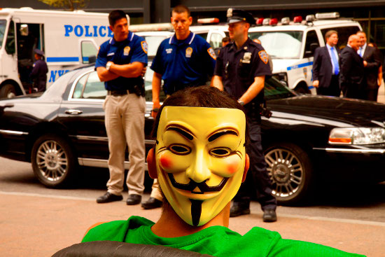 An Occupy Wall Street protester in front of three police officers. Photo by Linh Dinh.
