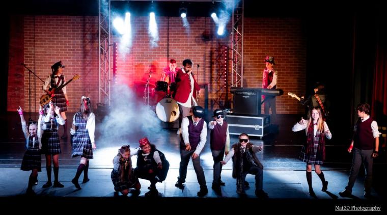 (left to right) Elena Skadal, Amelia Kipp, Addisen Kuffler, Tate Sommer, Charley Seneli, Antonio Casas, Cooper Tubbs, Brighton Greim, Taylor Tubbs, Jack Carslake (back left to right) Breleigh Moran, Henrick Senne, Adam Sanders, Enzo Passini, and Malcolm Fraser in School of Rock: The Musical (photo: Nat20 Photography)