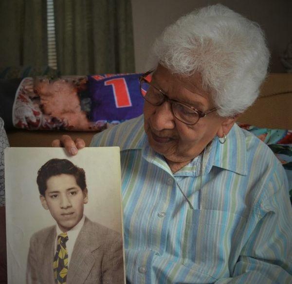 Mary Munos Ramirez (John's sister) with a photo of John